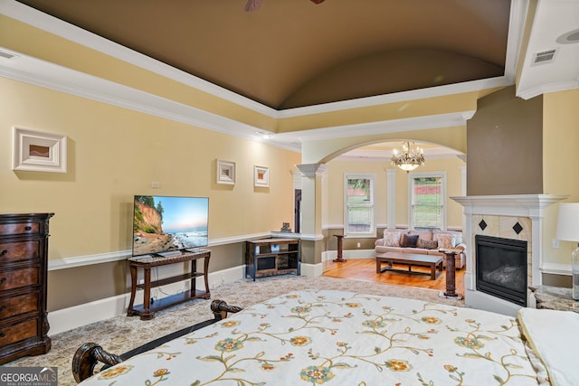 bedroom with a fireplace, ornamental molding, lofted ceiling, and a notable chandelier