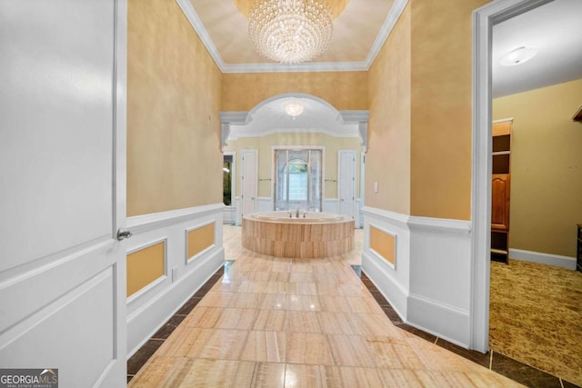 hall with an inviting chandelier and crown molding