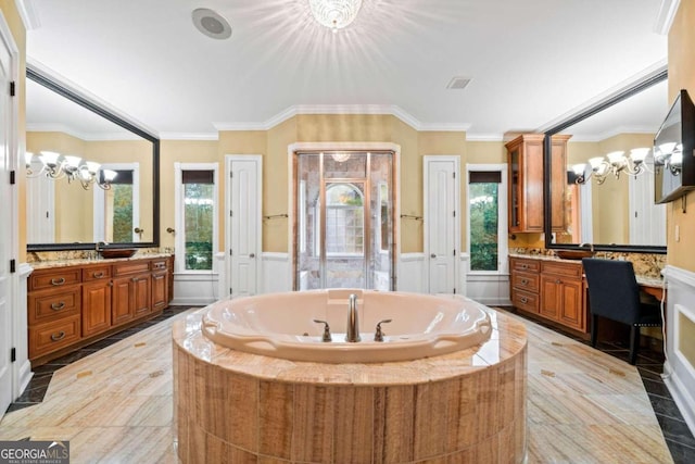 bathroom with ornamental molding, tiled bath, vanity, and an inviting chandelier