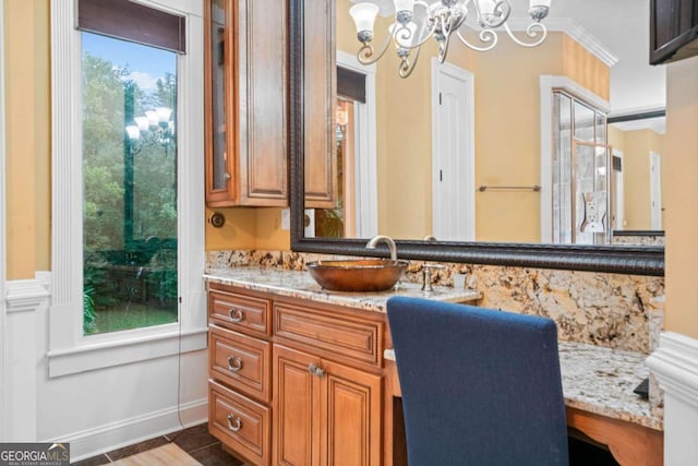 bathroom with an inviting chandelier, tile patterned floors, vanity, and crown molding