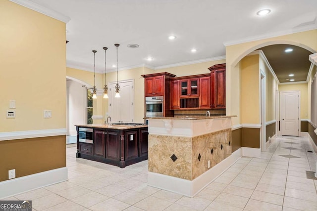 kitchen with a kitchen island, light tile patterned floors, stainless steel appliances, crown molding, and decorative light fixtures