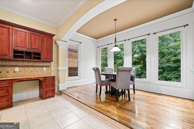 dining area featuring a healthy amount of sunlight, light hardwood / wood-style floors, and crown molding