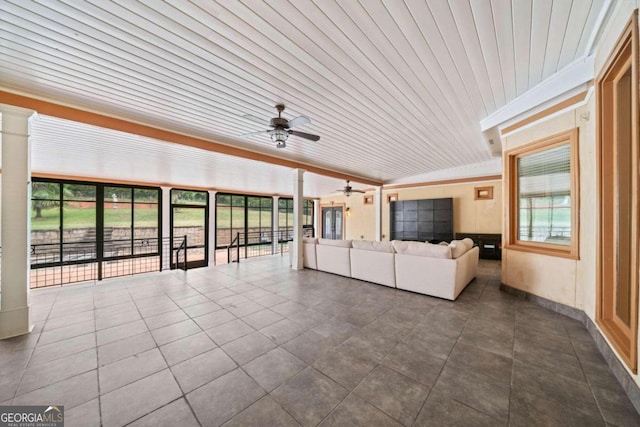 unfurnished sunroom with ceiling fan and wooden ceiling