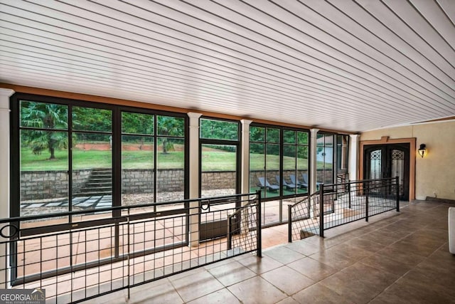 unfurnished sunroom with plenty of natural light and wooden ceiling