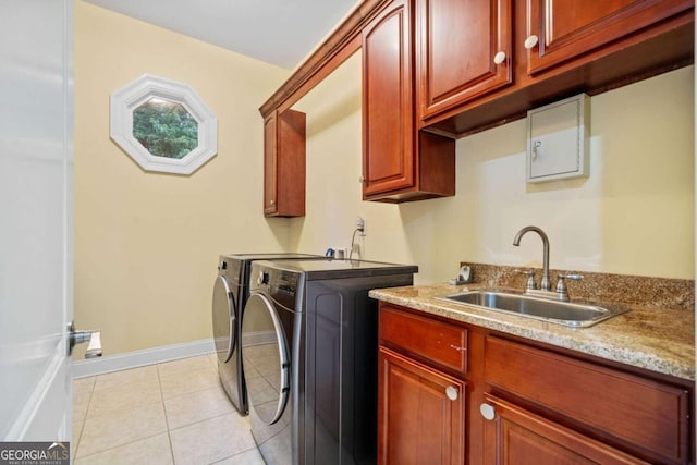 washroom with washing machine and dryer, sink, light tile patterned floors, and cabinets