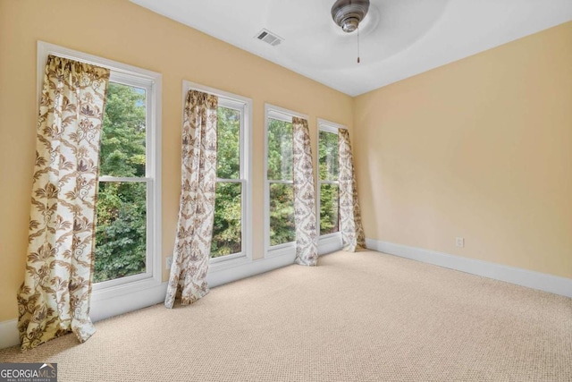 unfurnished room with ceiling fan, plenty of natural light, and carpet floors