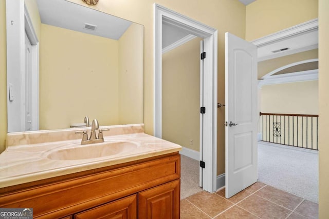 bathroom with crown molding, vanity, and tile patterned floors