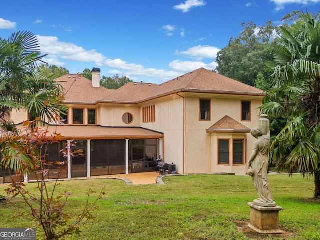 back of property with a yard and a patio