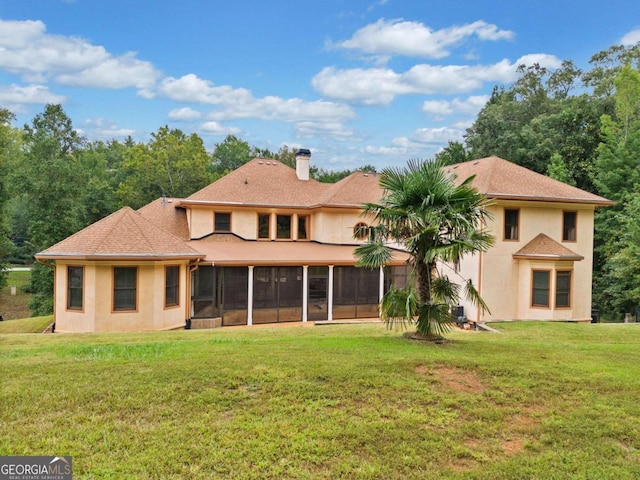 rear view of house featuring a sunroom and a yard