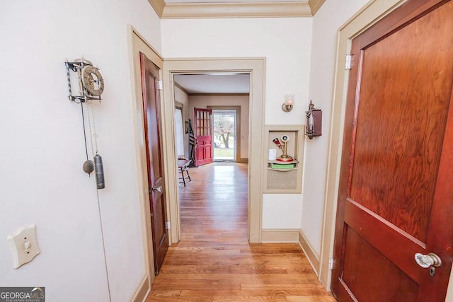 hall with light hardwood / wood-style flooring and ornamental molding