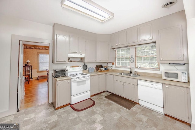 kitchen featuring white cabinets, white appliances, and sink