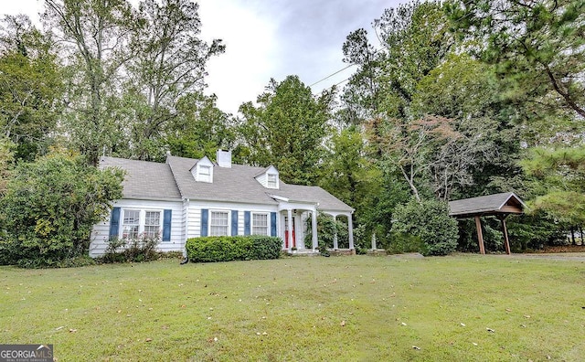 cape cod house featuring a front yard