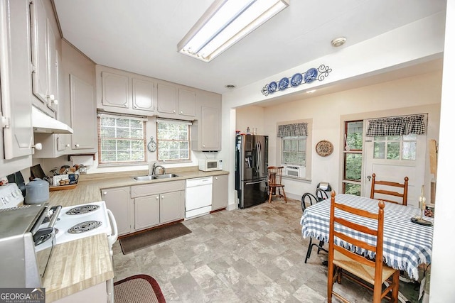 kitchen featuring cooling unit, sink, white cabinets, and white appliances