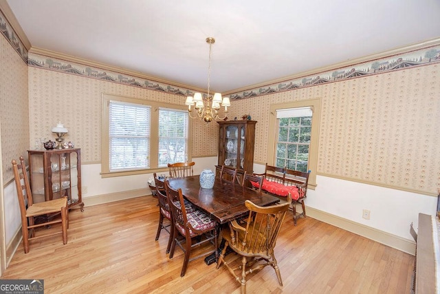 dining room featuring a chandelier, light hardwood / wood-style floors, and ornamental molding