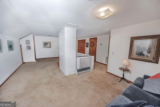 carpeted living room with decorative columns and lofted ceiling