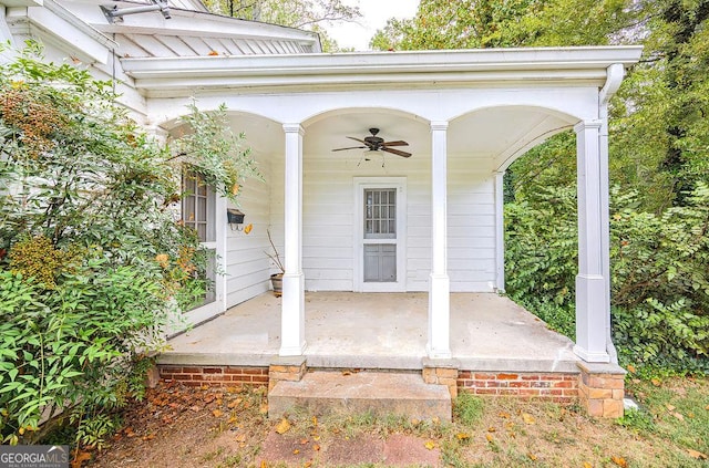 view of exterior entry with ceiling fan and covered porch