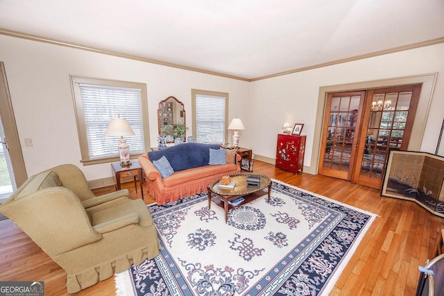 living room featuring hardwood / wood-style floors, crown molding, and french doors