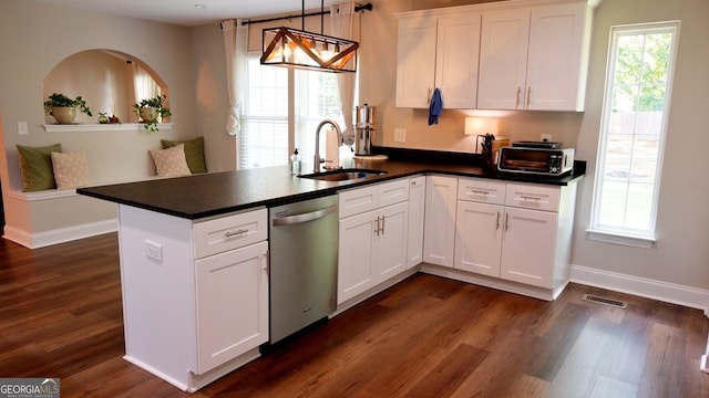 kitchen with pendant lighting, kitchen peninsula, stainless steel dishwasher, and white cabinets