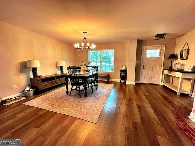 dining area with dark wood-type flooring and a notable chandelier