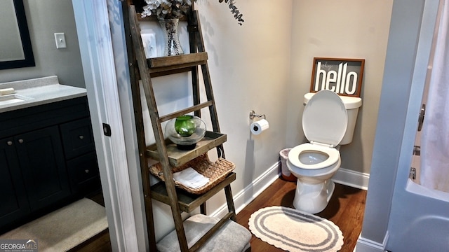 bathroom with vanity, toilet, and wood-type flooring