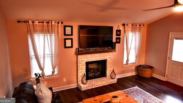 living room featuring a fireplace, dark hardwood / wood-style floors, and a healthy amount of sunlight