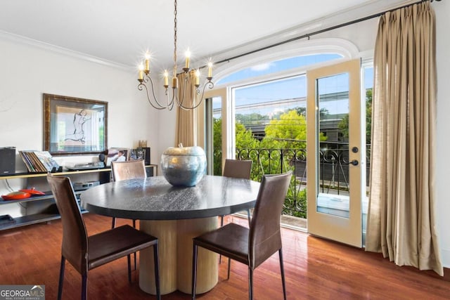 dining space with a wealth of natural light, an inviting chandelier, and dark hardwood / wood-style floors