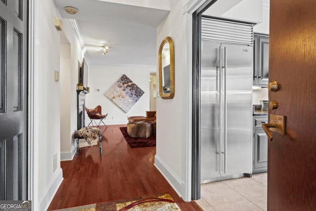 corridor featuring crown molding and light hardwood / wood-style flooring