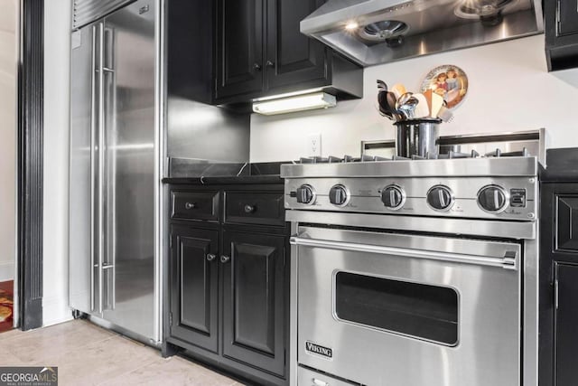 kitchen featuring exhaust hood, light tile patterned flooring, and premium appliances