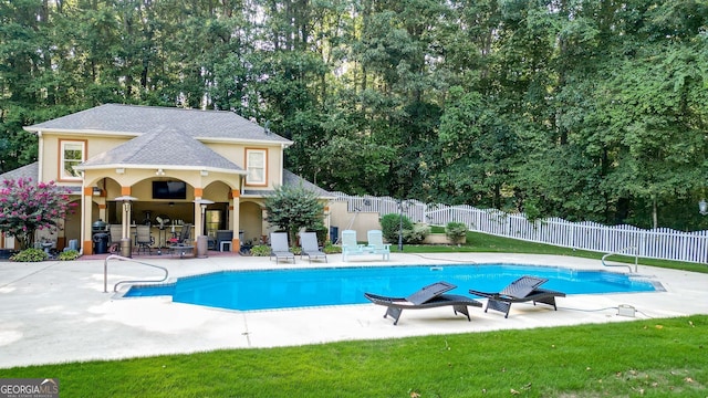 view of swimming pool with a yard and a patio