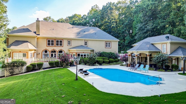 view of pool featuring a lawn and a patio