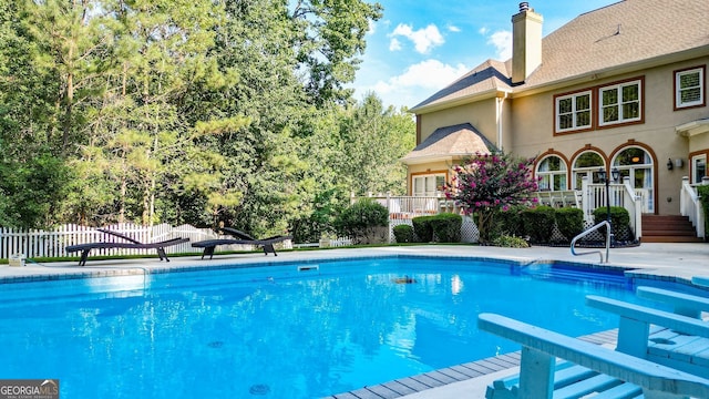 view of swimming pool with a diving board