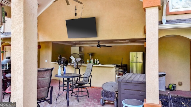 view of patio with ceiling fan and an outdoor bar