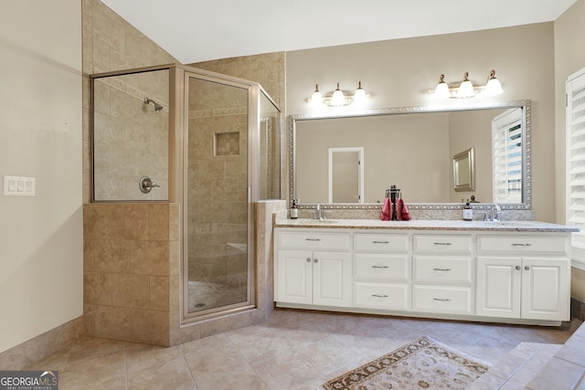 bathroom with walk in shower, vanity, and tile patterned flooring