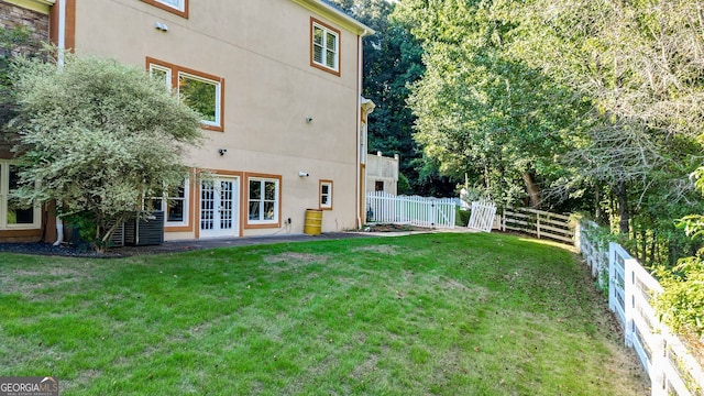 back of property with a yard and french doors