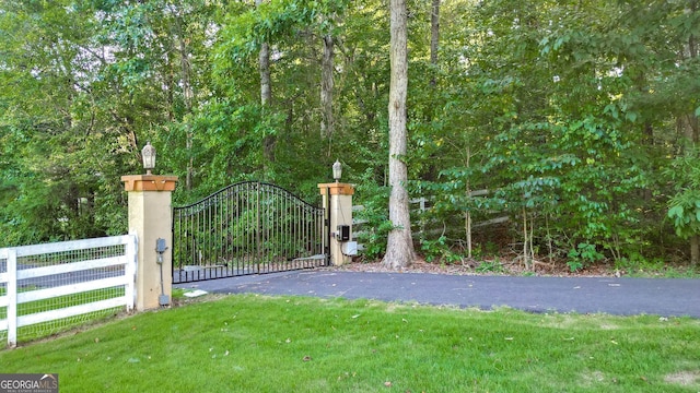 view of gate featuring a yard