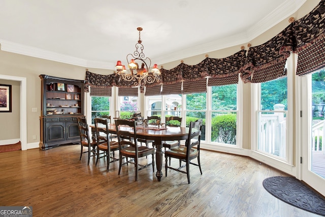 dining area featuring hardwood / wood-style floors, crown molding, and a chandelier