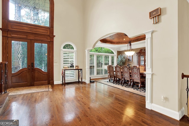 entrance foyer featuring dark hardwood / wood-style flooring, a towering ceiling, french doors, and a tray ceiling