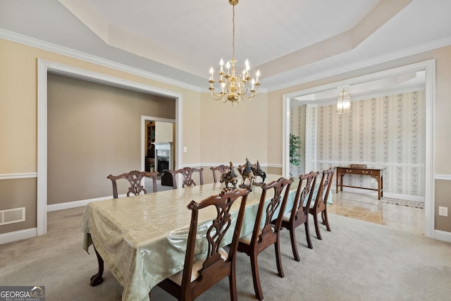 dining space with light colored carpet, a raised ceiling, crown molding, and a chandelier