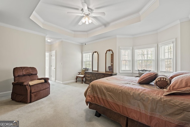 carpeted bedroom featuring crown molding, a tray ceiling, and ceiling fan