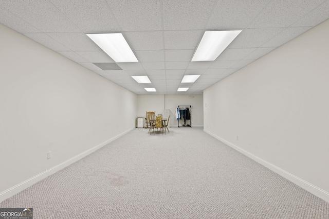 basement featuring a drop ceiling and carpet floors