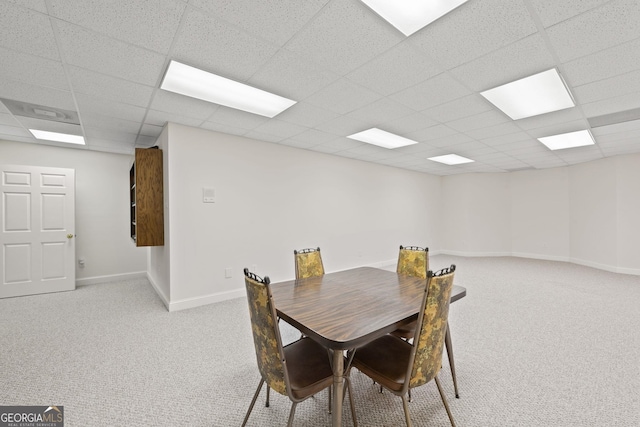 carpeted dining space featuring a paneled ceiling