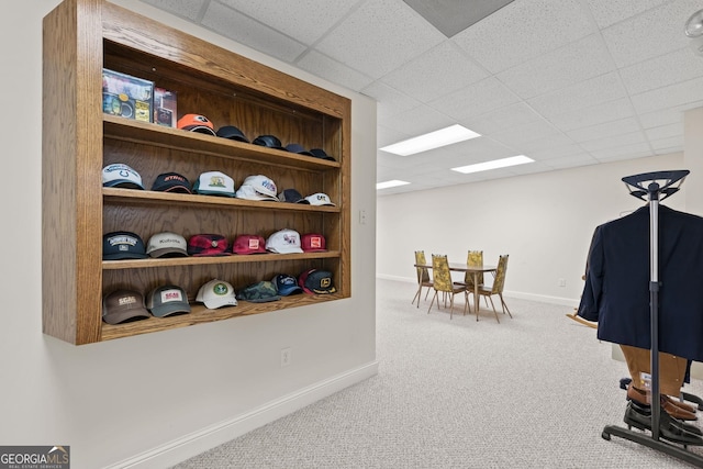 walk in closet with a paneled ceiling and carpet