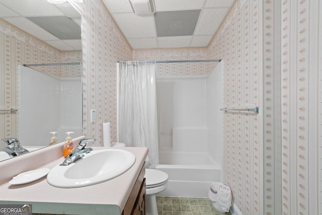 full bathroom featuring shower / bathtub combination with curtain, toilet, a drop ceiling, and vanity