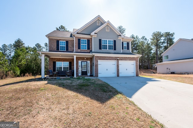 view of front of property with a garage, covered porch, and a front yard