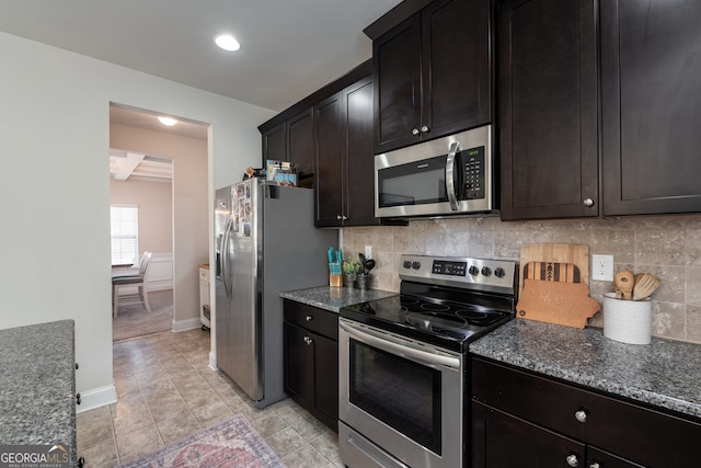 kitchen with backsplash, dark stone countertops, dark brown cabinetry, and appliances with stainless steel finishes