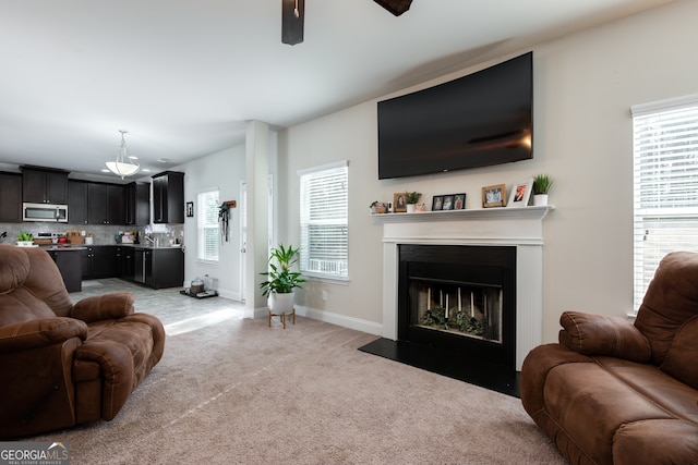 living room featuring light carpet, a wealth of natural light, and ceiling fan