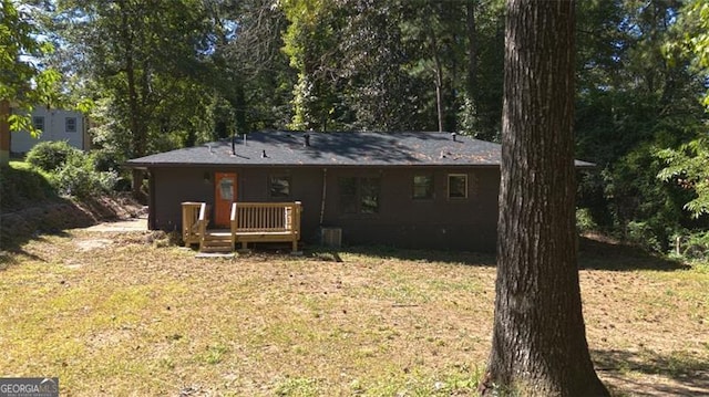 back of property featuring a yard and a wooden deck