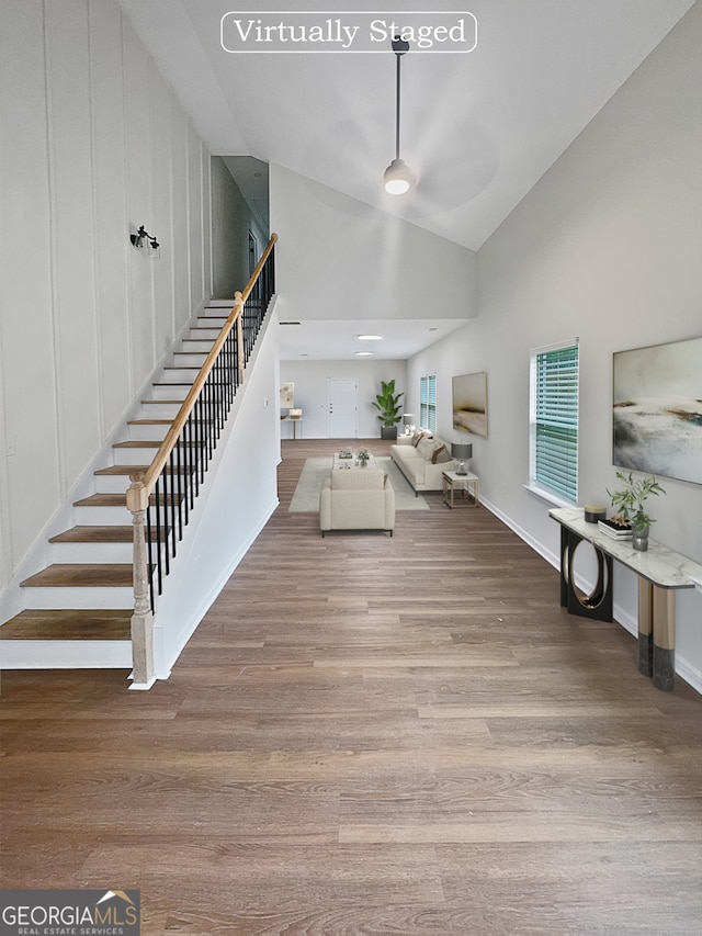 interior space with wood-type flooring and high vaulted ceiling