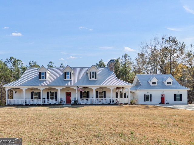 cape cod home featuring a front yard and covered porch