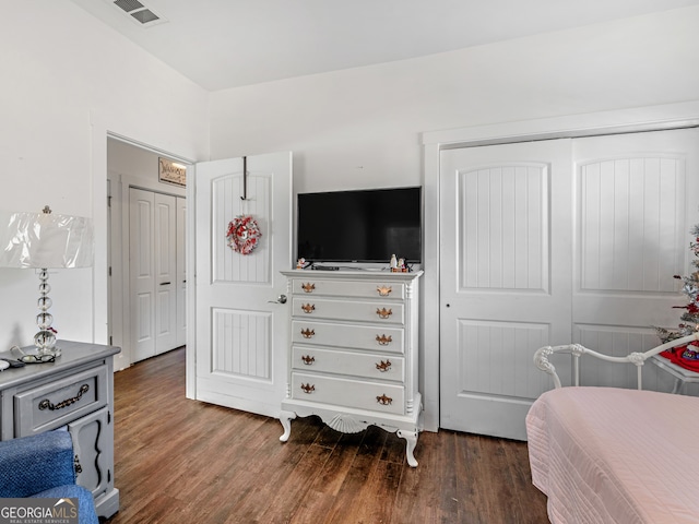 bedroom with dark wood-type flooring and a closet